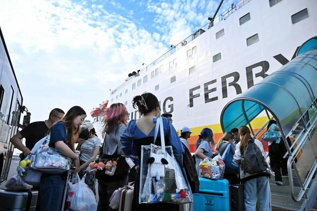 2025年10月1日，在青岛邮轮母港码头，旅客登上客货班轮“新金桥5号”。新华社记者 李紫恒 摄