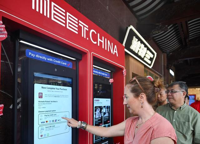 2025年9月27日，外籍嘉宾在上海豫园体验使用“Meet China”入境旅游数字消费大屏。新华社记者 陈浩明 摄
