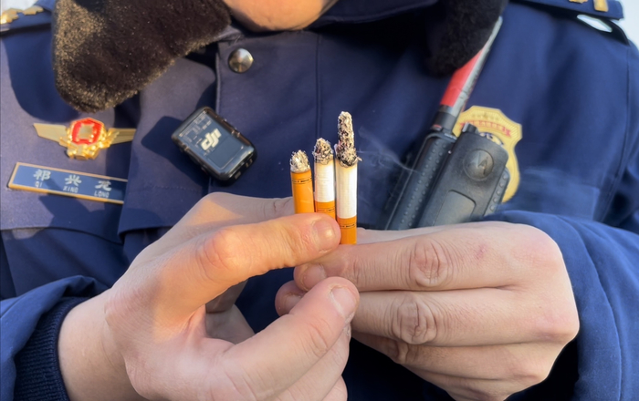 消防员从36米高空依次扔下的3支点燃的香烟，落地后依旧着着。新京报记者 张静姝 摄