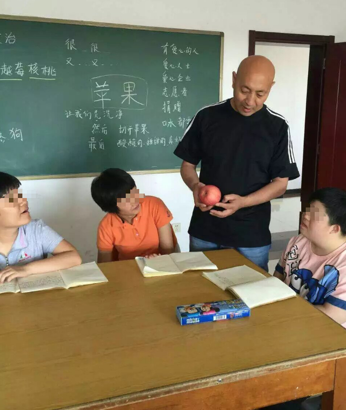 李旺拿着苹果教学生们观察外形、辨认特征。受访者供图