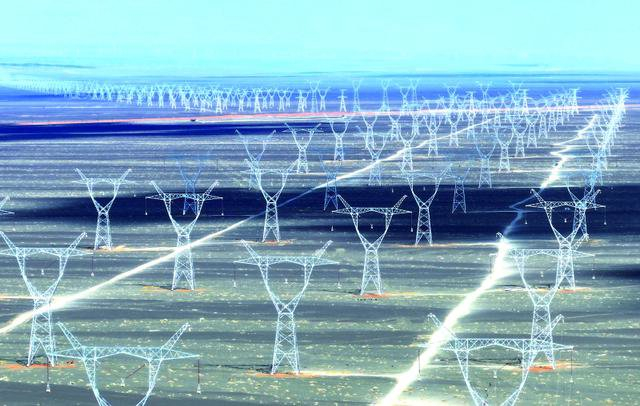 在巴里坤哈萨克自治县三塘湖镇附近拍摄的“疆电入渝”特高压工程。王菲/摄