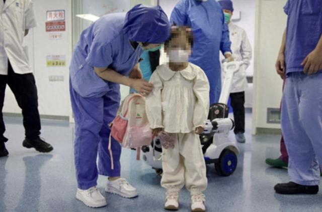 南京市儿童医院的医护人员与患儿交流互动图片来自新华社 