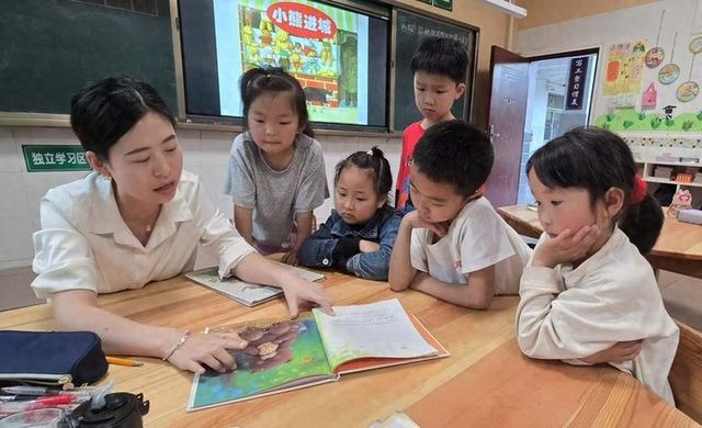 2025年4月17日，四川省广元市利州区宝轮镇范家小学的老师在给一年级学生讲绘本。新华社记者 吴晓颖 摄