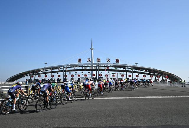 11月8日，第十五届全国运动会公路自行车男子个人赛决赛参赛选手经过港珠澳大桥闸口。新华社记者 邓华 摄