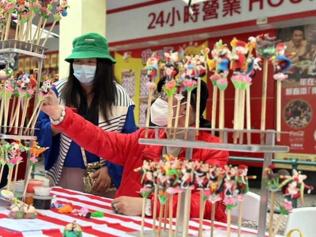 2023年1月23日，澳门新马路上的一家面塑技艺摊位吸引民众驻足。中新社记者 李亚南 摄