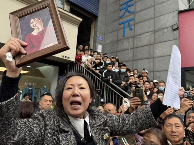 一审判决之后，受害人王某雅的母亲拿着判决书和女儿的照片离开法院。澎湃新闻记者 胥辉 摄