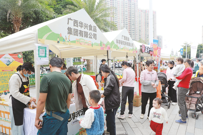     12月20日，兴宁区2025年全国县域商业“领跑县”展销活动在吾悦广场启幕。图为市民在活动中选购食品等。 （杨创通 摄）