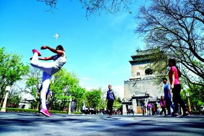 居民在钟鼓楼广场踢毽子。张传东摄/光明图片