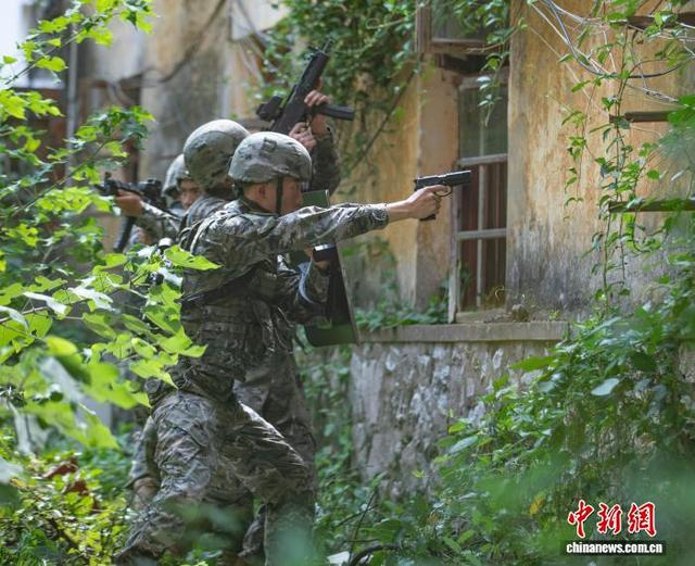 图为武警官兵在对房屋进行搜索。余海洋 摄 