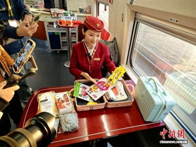12月26日，郭学敏正在列车上接受媒体采访。中新社记者 陈林 摄