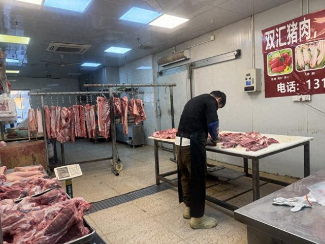 12月26日下午，上海最大肉类保供单位西郊国际农产品交易中心，猪肉摊主王成义正在分切猪肉。 澎湃新闻记者 邹娟 图