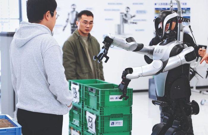 工作人员观察人形机器人搬运塑料筐的测试情况 杜潇逸 摄