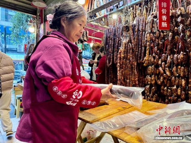 图为新开寺街一店员正在打包腊肉。何美锟 摄