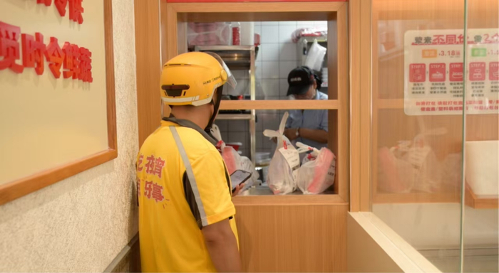 骑手在南城香外卖窗口，拿取拼好饭与品牌定制的套餐。（摄影：纪元）