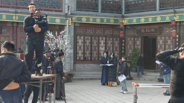 横店短剧拍摄现场，画面中间远处是男女主和导演。