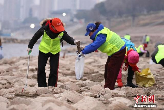 图为“三峡蚁工”在江边“净滩”迎新年。严晓冬 摄