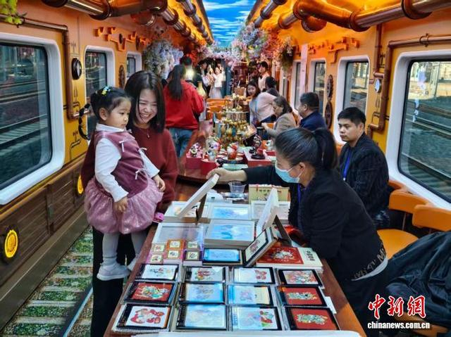 1月1日，中国首列沉浸式文旅专列“津旅时光号”正式开行天津北站至北京站跨城线路。图为旅客参观非遗产品。记者 佟郁 摄