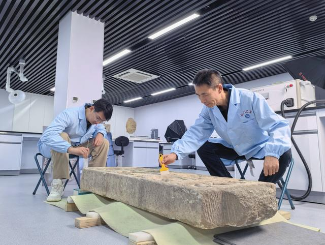 2025年12月31日，马朝龙（右）和同事正在清理一块北齐时期的造像碑。新华社记者 袁月明 摄