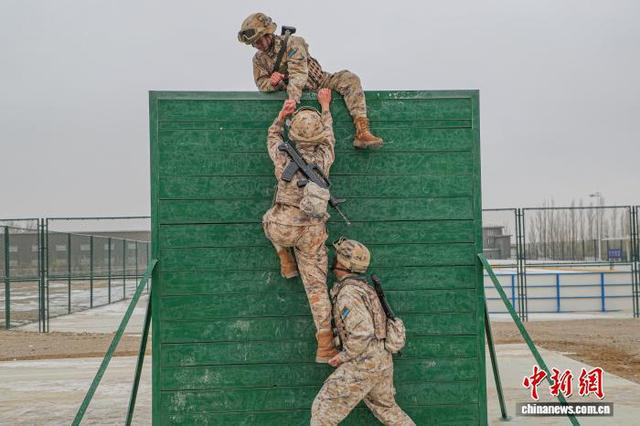 图为多人协作翻越高墙。 郭田耒 摄