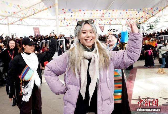 图为农牧民妇女“村T”秀结束后， 参演人员和游客一起跳锅庄。 中新社记者 李林 摄