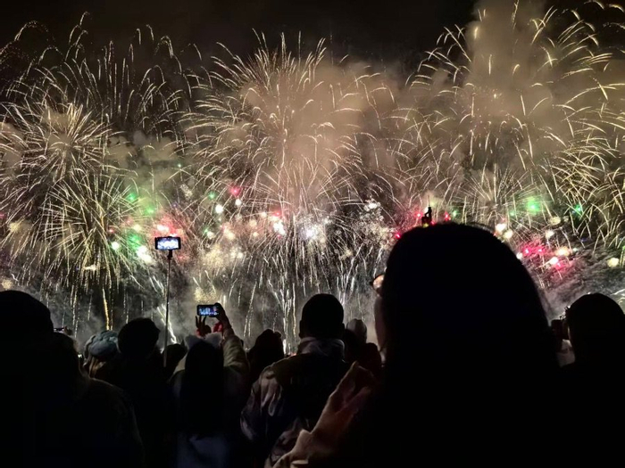（图注：重庆人民在拍摄跨年烟花秀，文静摄）
