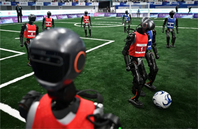 2025年8 月，在北京举办的首届人形机器人运动会上，机器人“选手”们正参与“五人制”足球比赛。 （图源：路透社）
