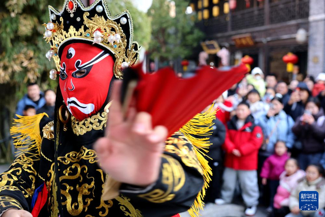 1月1日，在京杭大运河畔的山东省枣庄市台儿庄古城，民间艺人在进行“变脸”表演。新华社发（孙中喆 摄）