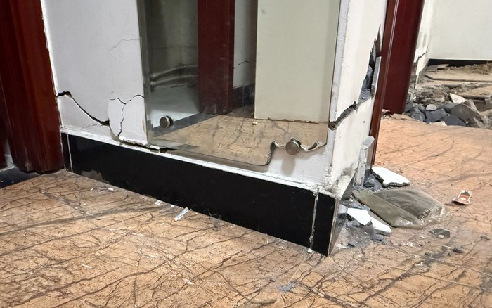 因墙体开裂，冯女士家卫生间外的仪容镜一角已被挤碎。新京报记者 张建林 摄