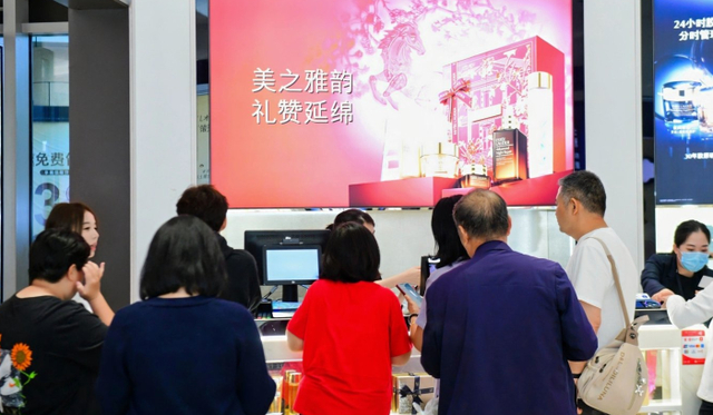 游客排队付款。 陈炳衡/摄