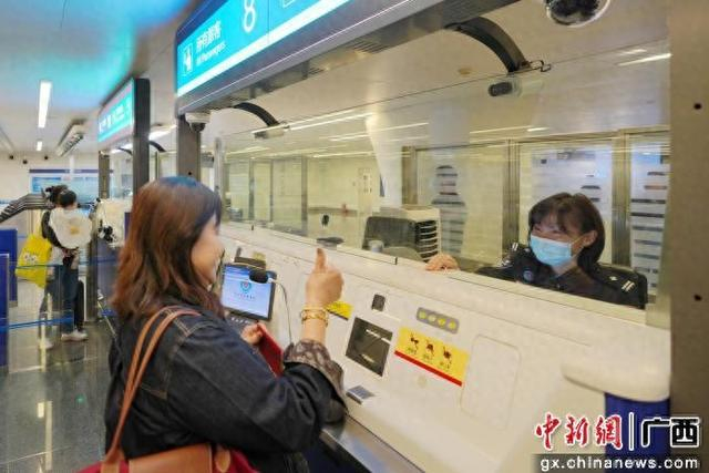1月4日，一名新加坡籍旅客在南宁口岸顺利通关后，向值守的移民管理警察竖起大拇指，为高效暖心的通关服务点赞。梁箫 摄