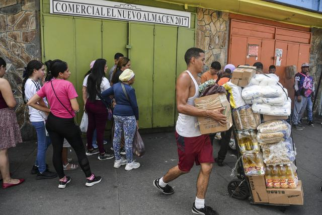当地时间2026年1月4日，委内瑞拉加拉加斯，人们在商店门口排队等待购买生活用品。视觉中国 图