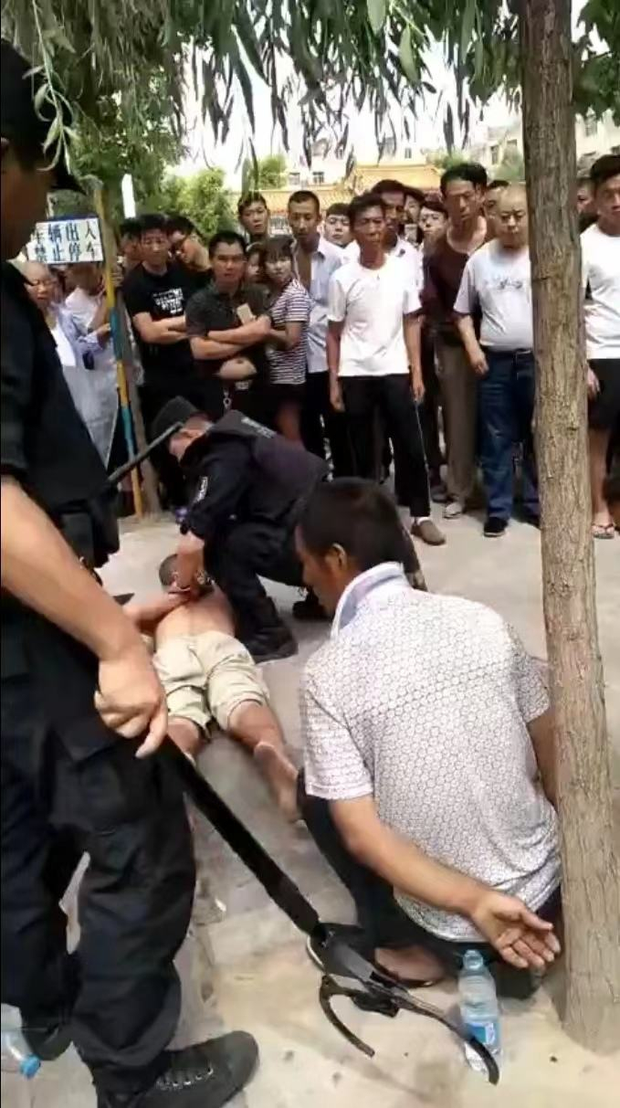 案发后，王爱武（趴在地上者）当场被捕。受访者供图