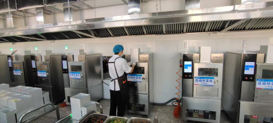 图为一名操作员正同时操作10台智能炒菜机器人