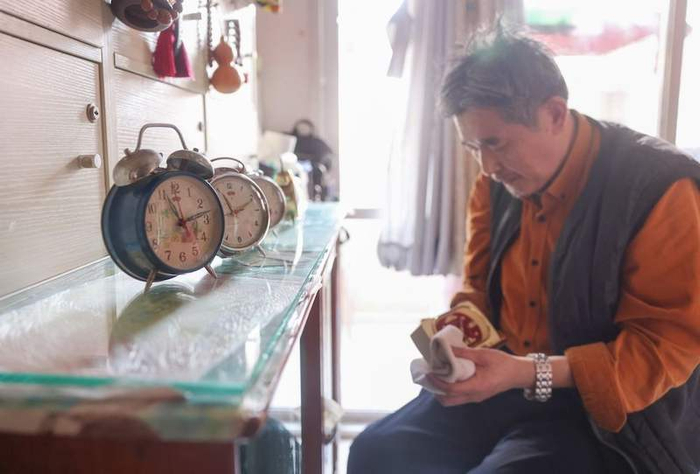 刘宪平的老伴儿在保养家中的老闹钟。