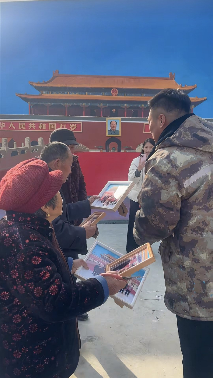 2025年12月25日，吳承言把天安門墻畫前的合照發給村里的老人們。受訪者供圖