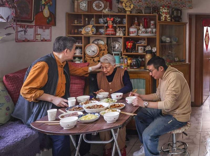 中午关店后，刘宪平一家人围坐在桌前吃饭。