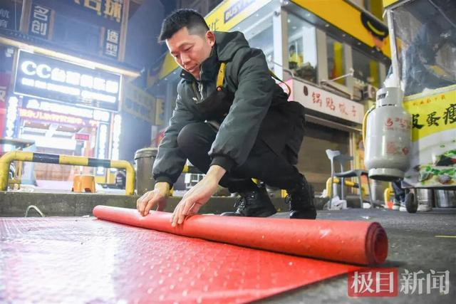 收摊后，何理卷起地上的防水布（极目新闻记者 黄志刚 摄）