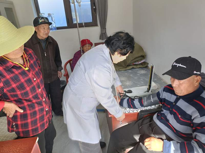 晋怀花（中）为村民测量血压。首都文明办供图