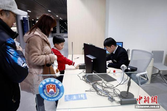 市民带着孩子在长宁公安分局出入境管理支队红宝石路接待大厅采集指纹。中新网记者 殷立勤 摄