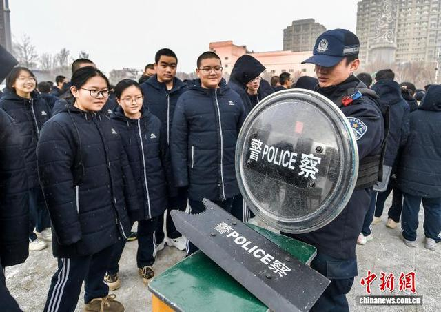 1月9日，新疆乌鲁木齐市第十九中学，民警向学生们展示警用盾牌。中新社记者 刘新 摄
