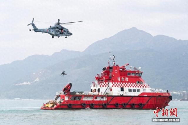图为香港特区政府飞行服务队的直升机和消防处船只配合，移送一名从海上救起的“生还者”。 中新网记者 侯宇 摄