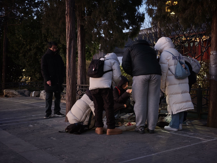 天色渐暗，围着“木雕大爷”的人群渐渐少了。新京报记者 王巍 摄