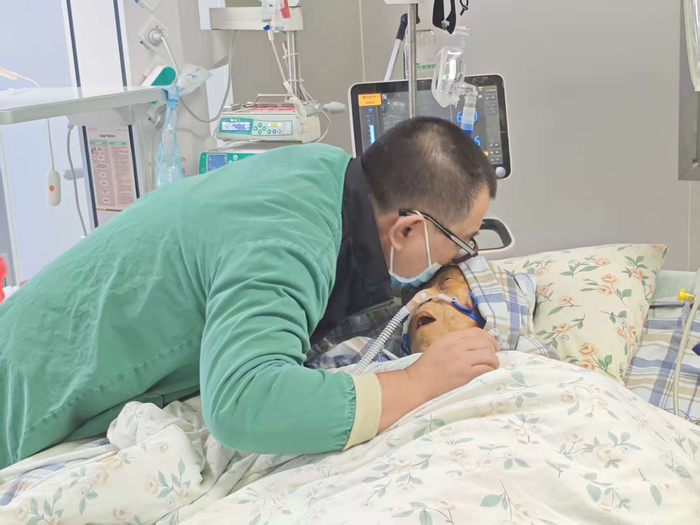 1月2日，母亲病情恶化时，黄海乐亲吻她的额头，希望传递爱的力量。受访者供图