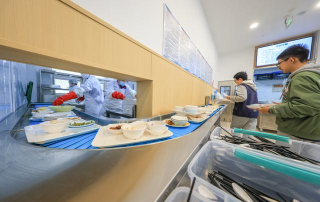 食堂配备了餐盘回收传送带。本报记者潘之望摄