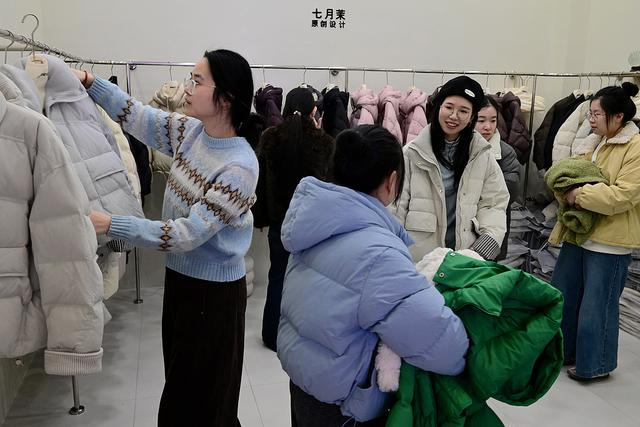 2025年12月28日，浙江嘉兴，客商在平湖市“平湖·中国服装城”的一家商铺内洽谈、选购羽绒服。视觉中国 资料图