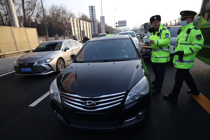 一辆悬挂临牌的“黑车”被交警和交通执法人员拦停，接受联合执法调查。新京报记者 王贵彬 摄
