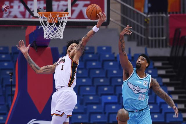 1月15日，青岛崂山啤酒队球员米奇（右）与吉林长白山恩都里队球员威尔逊在比赛中拼抢。新华社记者 李紫恒 摄