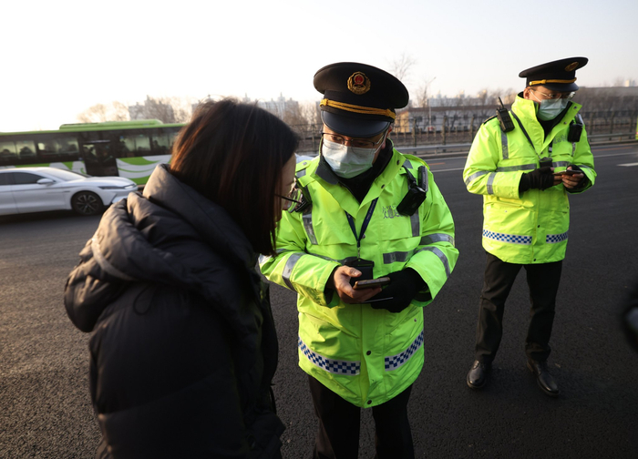 交通执法人员向乘客询问情况。新京报记者 王贵彬 摄