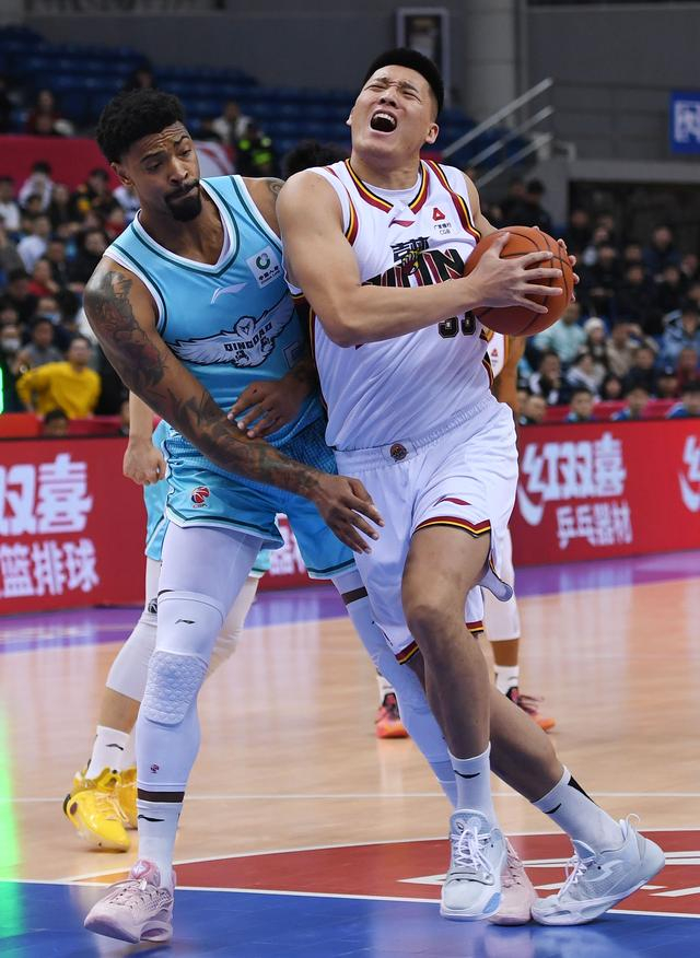 1月15日，青岛崂山啤酒队球员米奇（左）在比赛中防守吉林长白山恩都里队球员曾繁日。新华社记者 李紫恒 摄