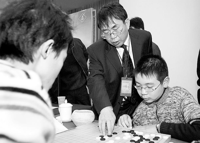     2005年西南棋王围棋赛，聂卫平指点成都小棋手。    本报资料图片
